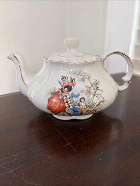 Vintage ceramic English teapot with transfer printer harlequin figures.